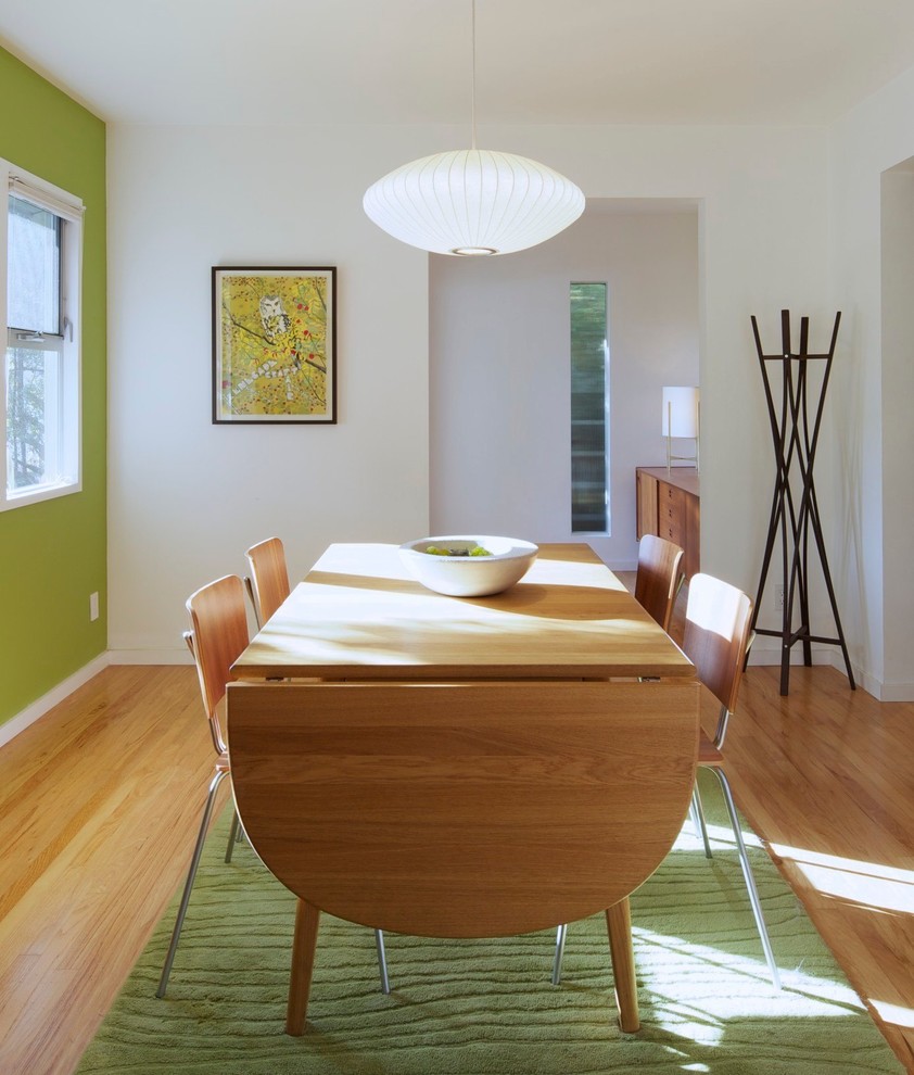 Idee per una sala da pranzo moderna con pareti bianche e pavimento in legno massello medio