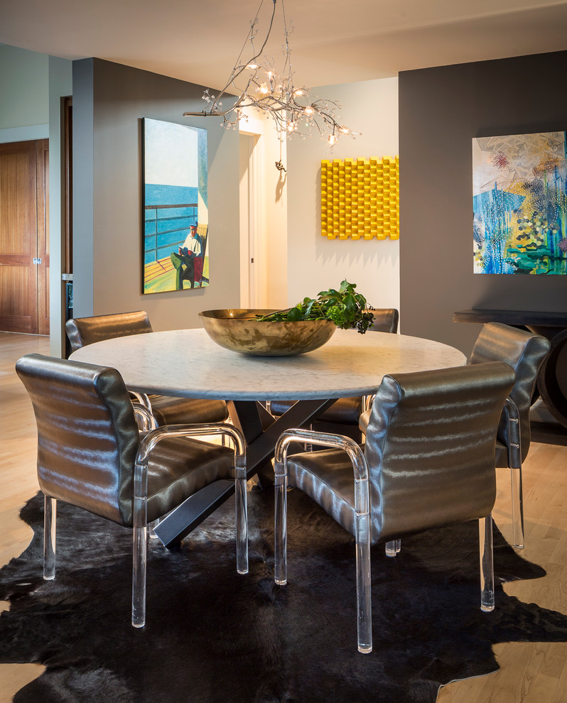 Cette image montre une salle à manger design avec un mur gris et un sol en bois brun.