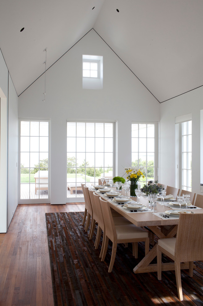 Immagine di una sala da pranzo stile marinaro chiusa e di medie dimensioni con pareti bianche e pavimento in legno massello medio