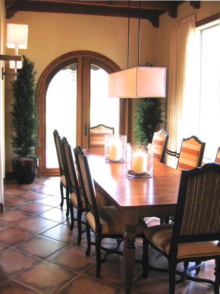 Immagine di una grande sala da pranzo aperta verso la cucina mediterranea con pareti beige, pavimento in terracotta, nessun camino e pavimento marrone