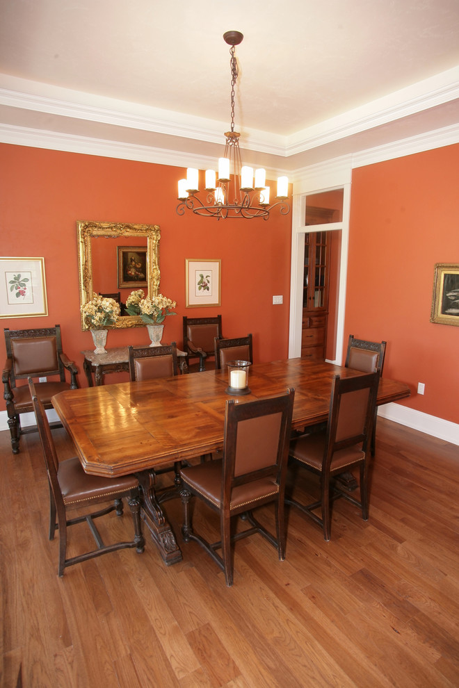 Foto de comedor clásico de tamaño medio cerrado con parades naranjas y suelo de madera en tonos medios