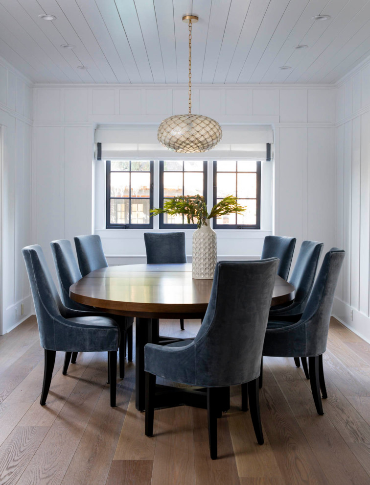 Immagine di una sala da pranzo aperta verso il soggiorno american style di medie dimensioni con pareti bianche e parquet chiaro
