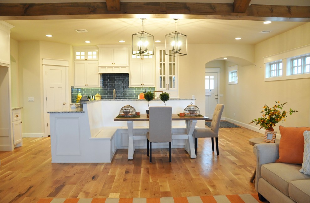 Cette image montre une salle à manger ouverte sur la cuisine craftsman de taille moyenne avec un mur blanc, un sol en bois brun, aucune cheminée et un sol beige.