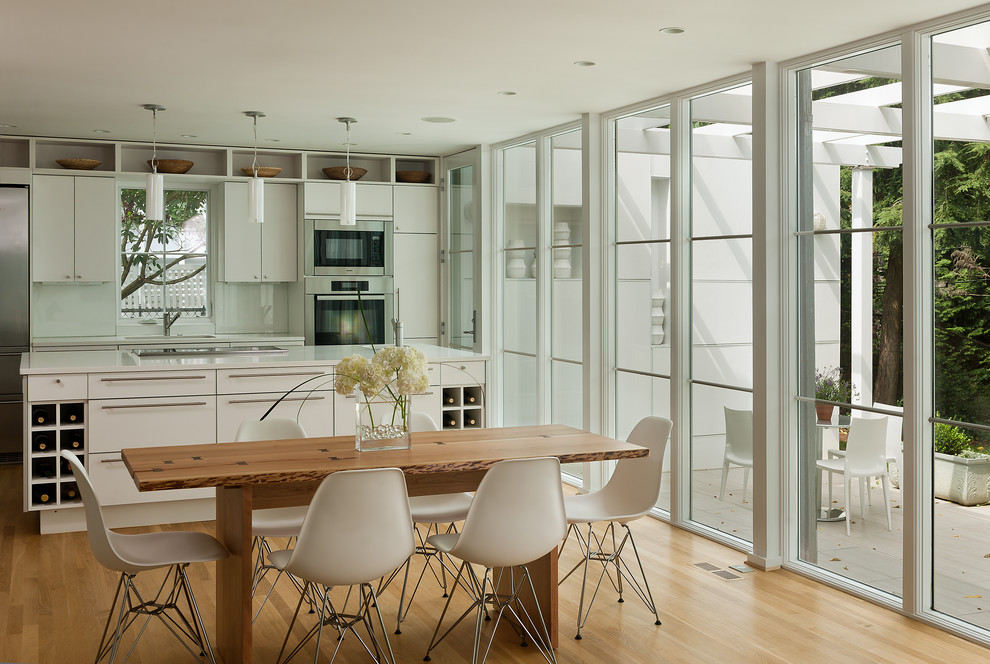 Immagine di una sala da pranzo aperta verso la cucina classica con parquet chiaro
