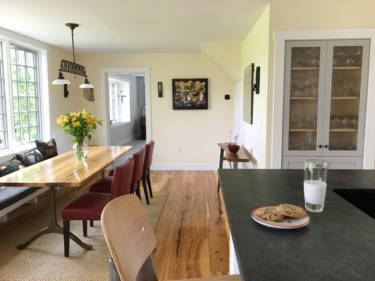 Exemple d'une salle à manger ouverte sur la cuisine chic de taille moyenne avec un mur jaune et un sol en bois brun.
