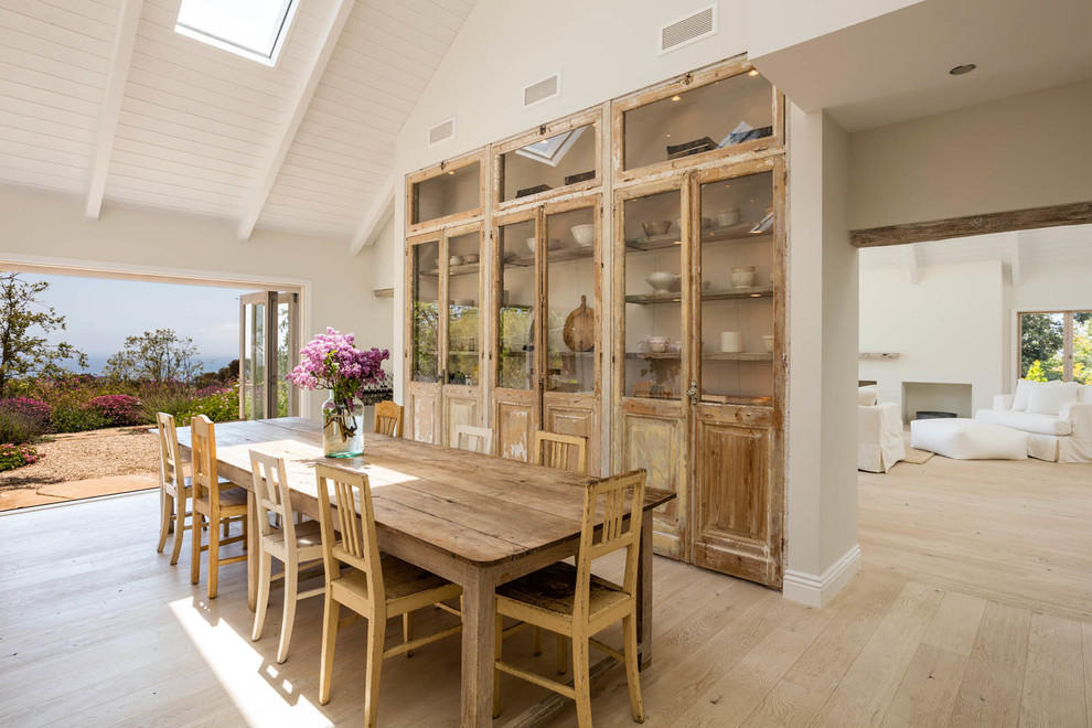 Design ideas for a country dining room in Los Angeles with white walls, light hardwood flooring and beige floors.