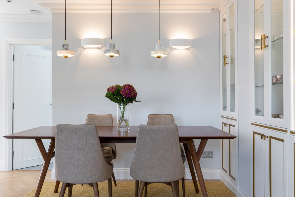 Foto di una sala da pranzo minimalista di medie dimensioni con pareti blu e parquet chiaro