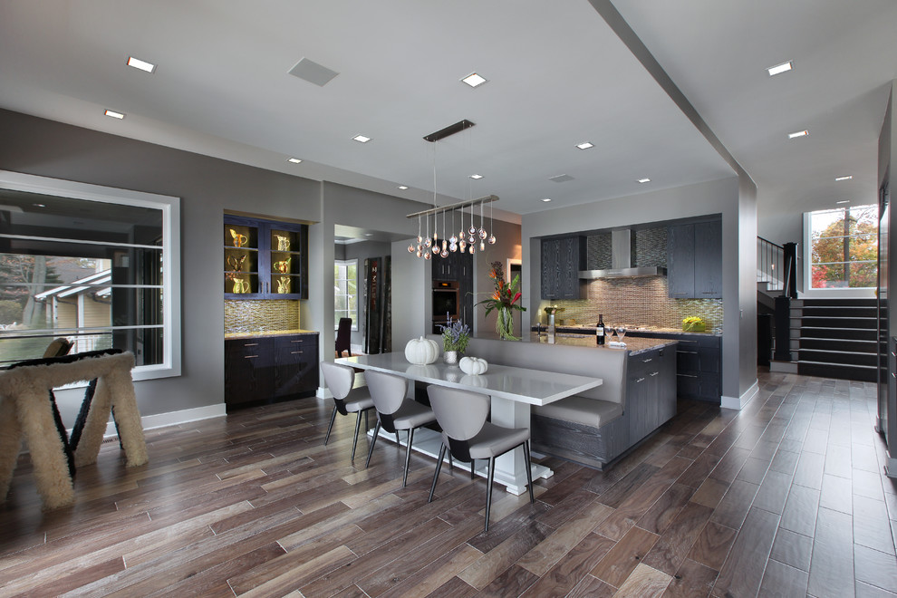 Esempio di una grande sala da pranzo aperta verso la cucina minimal con pavimento in legno massello medio e pavimento marrone