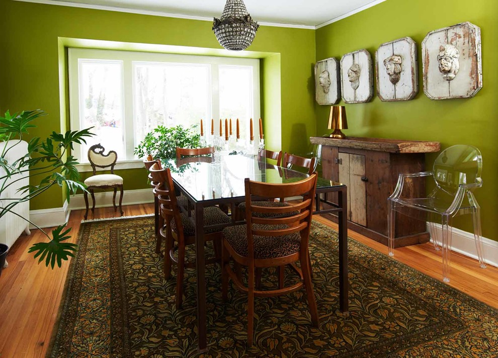 Exemple d'une salle à manger éclectique fermée et de taille moyenne avec un mur vert et parquet clair.