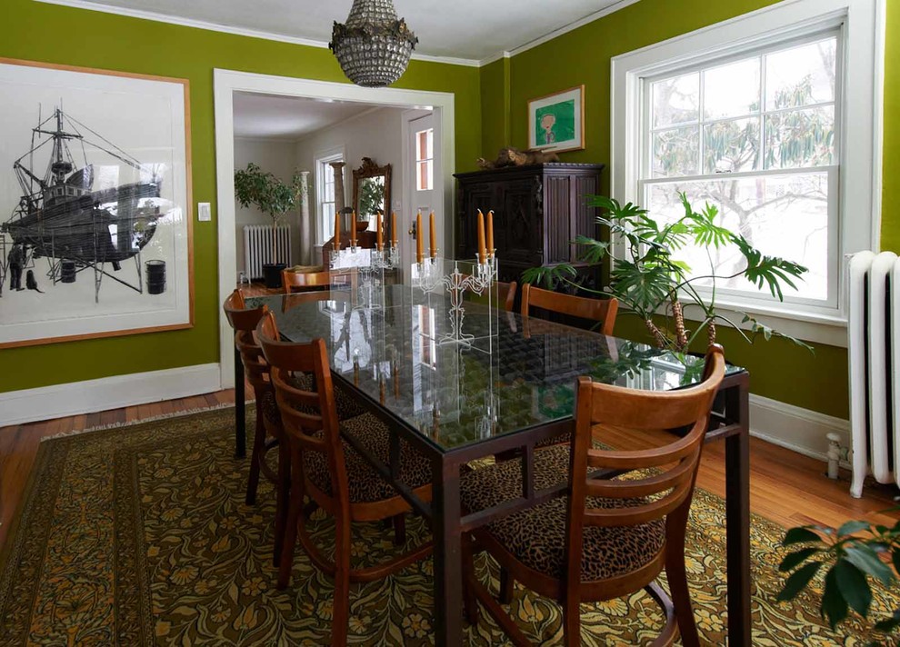 Réalisation d'une salle à manger bohème fermée et de taille moyenne avec un mur vert et parquet clair.
