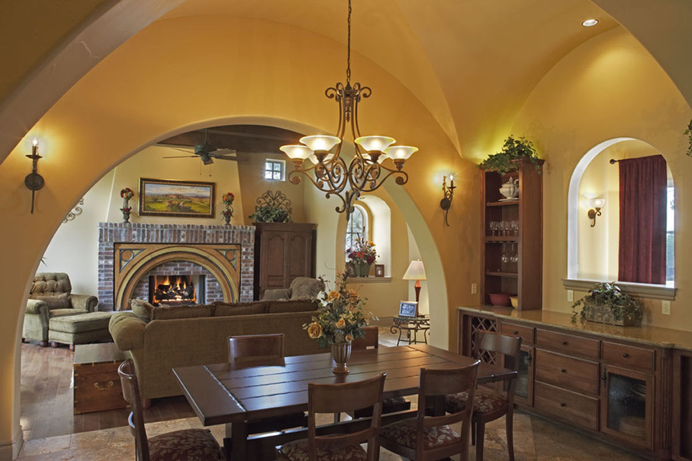 Inspiration for a rustic dining room in Austin with yellow walls, dark hardwood flooring and feature lighting.