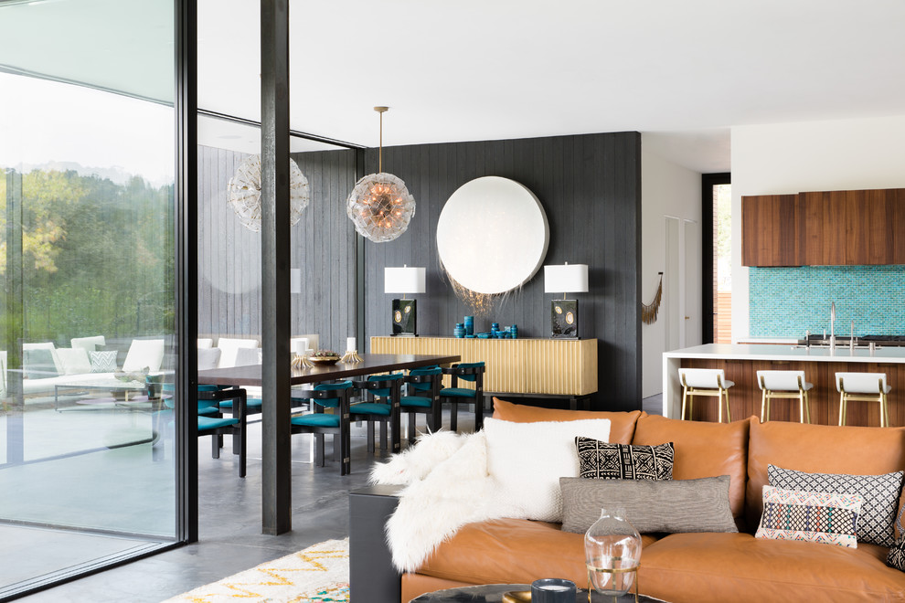 На фото: гостиная-столовая в современном стиле с черными стенами, бетонным полом и серым полом с