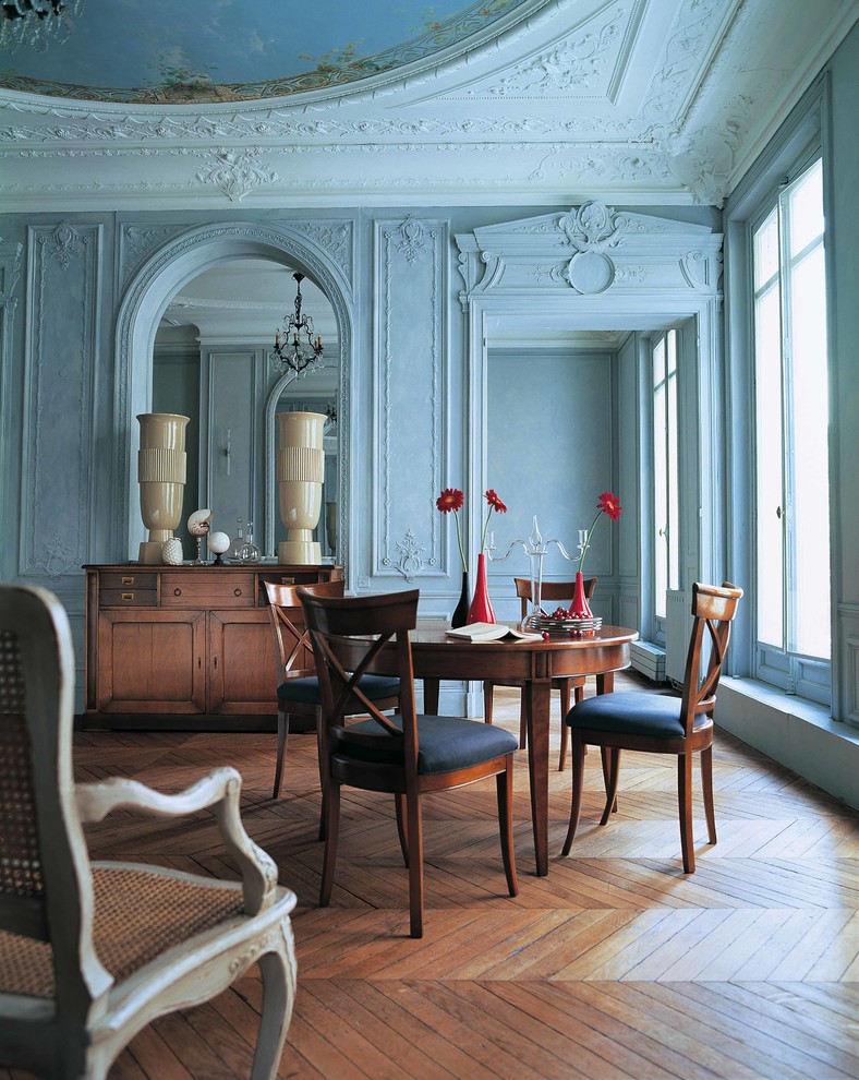 Aménagement d'une salle à manger classique avec un mur bleu et un sol en bois brun.