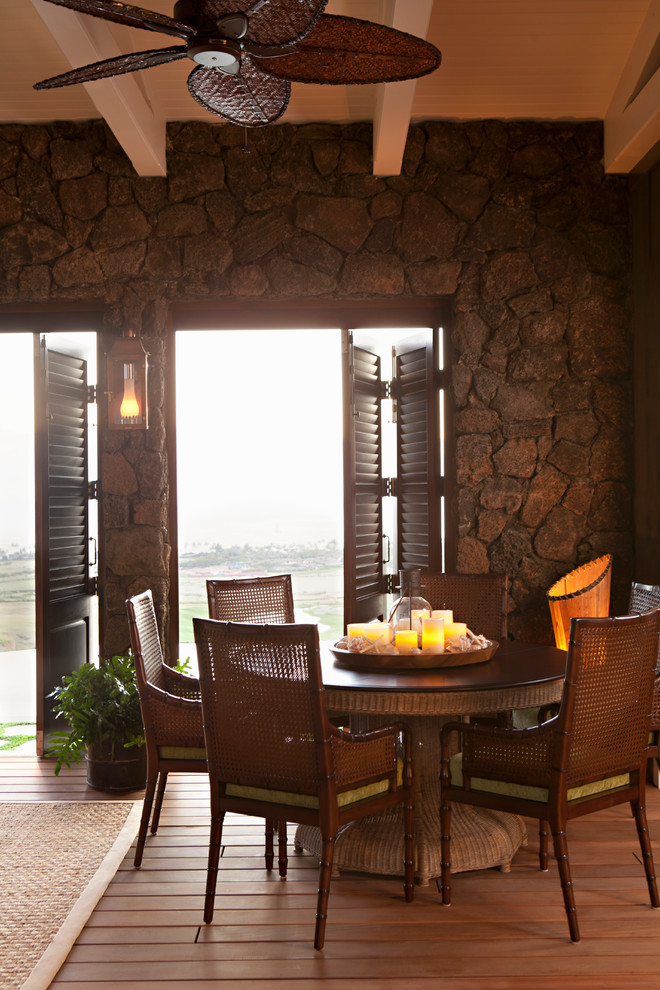 Immagine di una sala da pranzo tropicale con parquet scuro e pavimento marrone