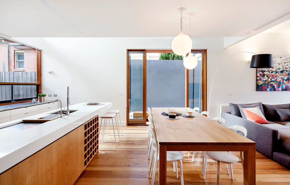 Cette image montre une salle à manger ouverte sur la cuisine design de taille moyenne avec parquet clair.