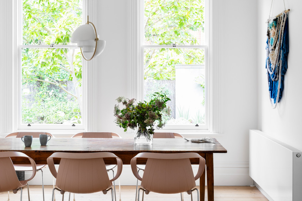 Idee per una sala da pranzo design con pareti bianche, parquet chiaro e pavimento beige