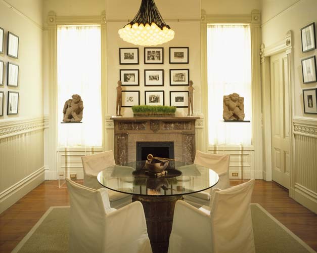 Foto de comedor bohemio de tamaño medio cerrado con paredes blancas, suelo de madera en tonos medios, todas las chimeneas y marco de chimenea de piedra