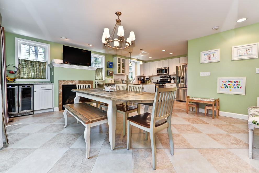 На фото: кухня-столовая в классическом стиле с зелеными стенами и стандартным камином
