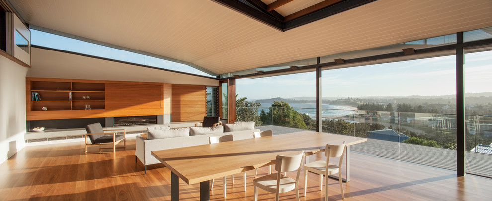 Offenes, Großes Modernes Esszimmer mit braunem Holzboden, Gaskamin und Kaminumrandung aus Metall in Sydney