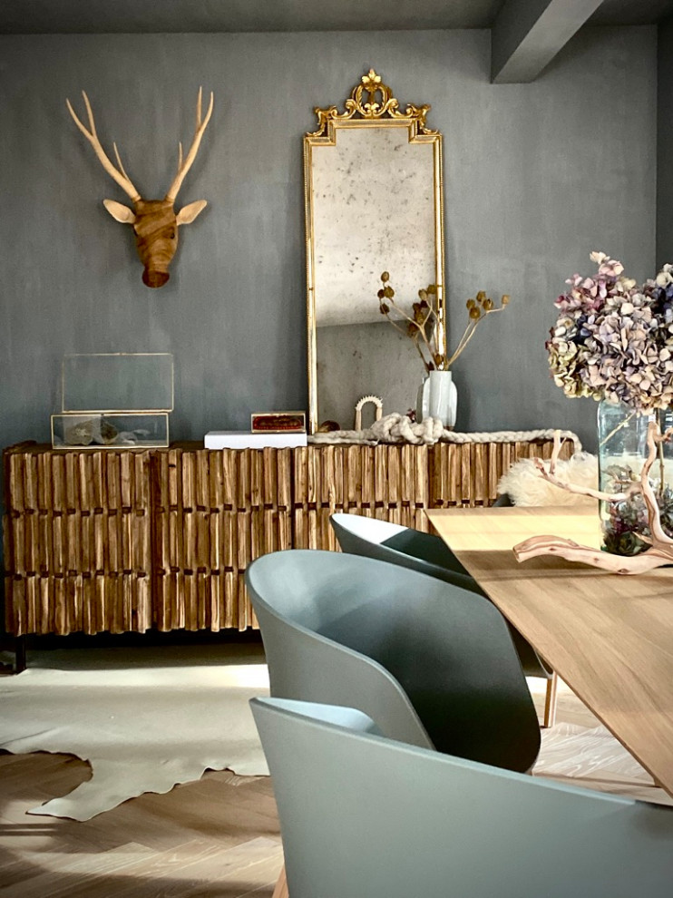 Immagine di una sala da pranzo boho chic chiusa e di medie dimensioni con pareti grigie, parquet chiaro e pavimento beige