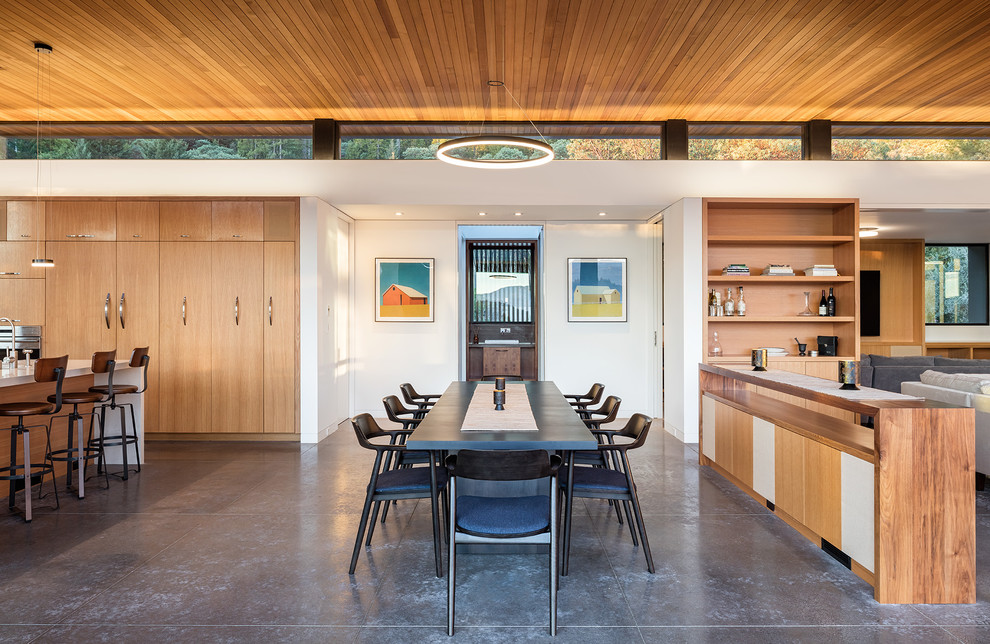 Стильный дизайн: гостиная-столовая среднего размера в современном стиле с белыми стенами и бетонным полом без камина - последний тренд