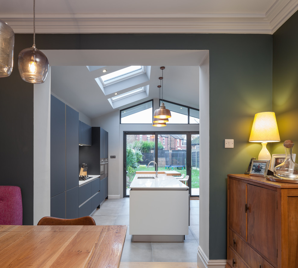 Mittelgroße Wohnküche mit grüner Wandfarbe und braunem Holzboden in Manchester