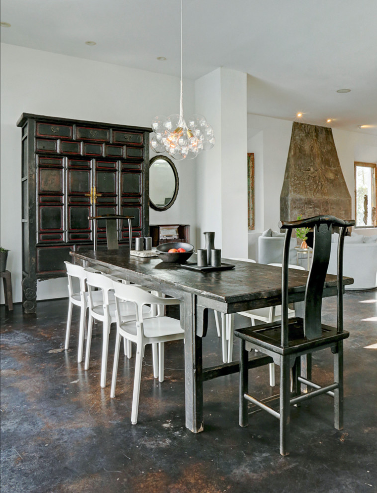 Idee per una sala da pranzo aperta verso il soggiorno american style di medie dimensioni con pareti bianche e pavimento in cemento