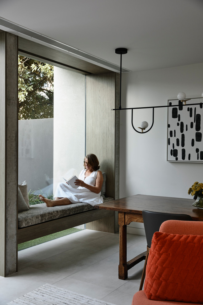 Réalisation d'une petite salle à manger ouverte sur le salon design avec un mur blanc, un sol en carrelage de porcelaine et un sol gris.