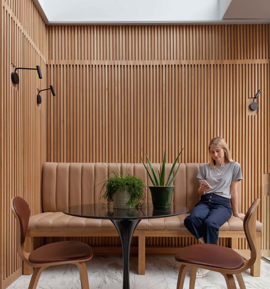Esempio di un angolo colazione minimal di medie dimensioni con pareti marroni, pavimento grigio e pareti in legno