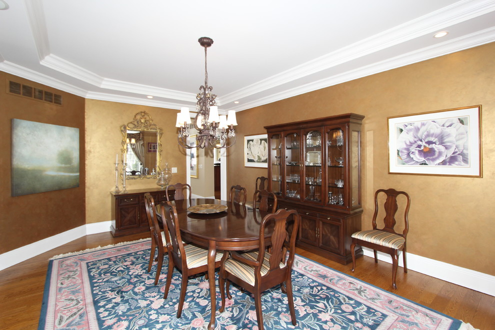 Aménagement d'une salle à manger ouverte sur le salon classique de taille moyenne avec mur métallisé et un sol en bois brun.
