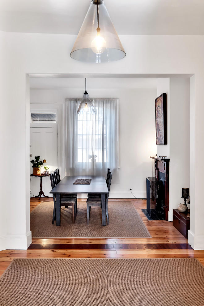 Inspiration pour une salle à manger design de taille moyenne avec un mur blanc, parquet clair et un sol marron.