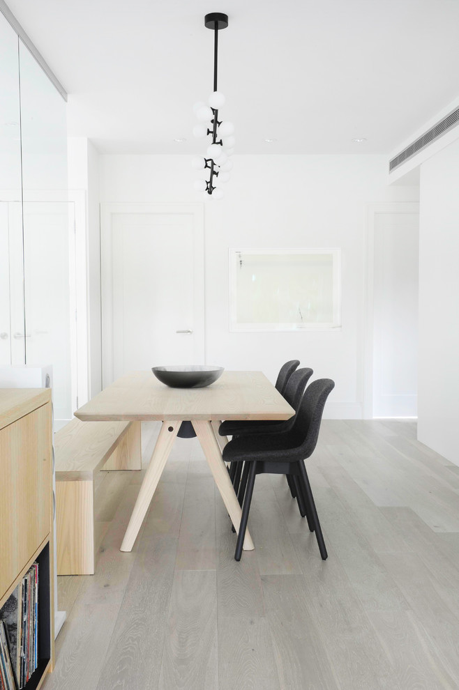 Ispirazione per una sala da pranzo aperta verso il soggiorno scandinava di medie dimensioni con pareti bianche e parquet chiaro