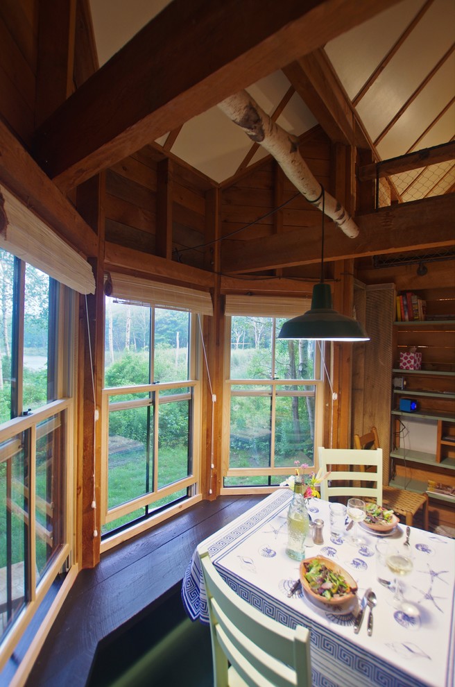 Esempio di una piccola sala da pranzo aperta verso il soggiorno stile rurale con pavimento in legno verniciato, stufa a legna, cornice del camino in metallo e pavimento verde