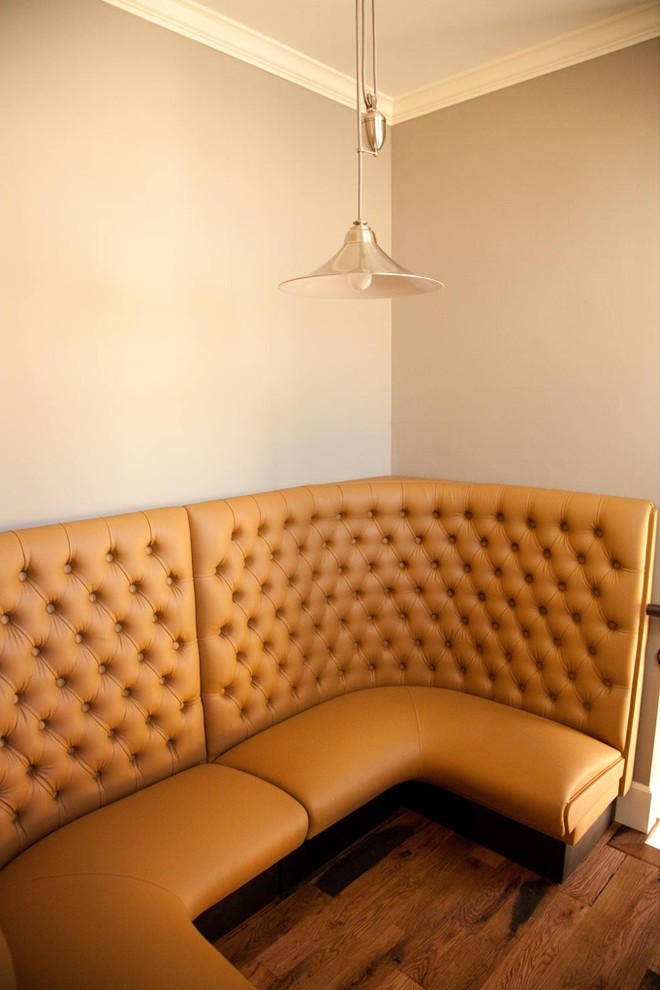 Cette image montre une salle à manger traditionnelle avec un mur beige et parquet foncé.