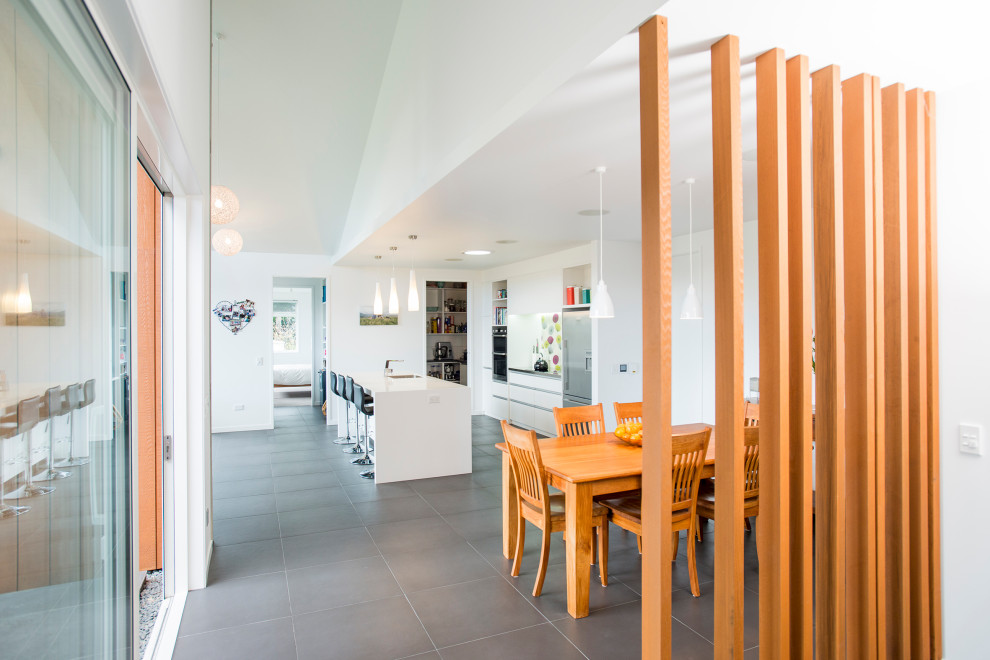 Medium sized modern kitchen/dining room in Napier-Hastings with white walls, ceramic flooring and grey floors.