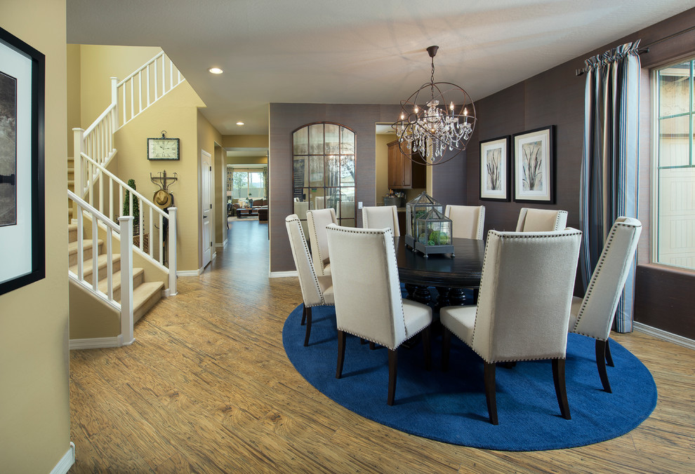 This is an example of a classic dining room in Phoenix with grey walls and medium hardwood flooring.