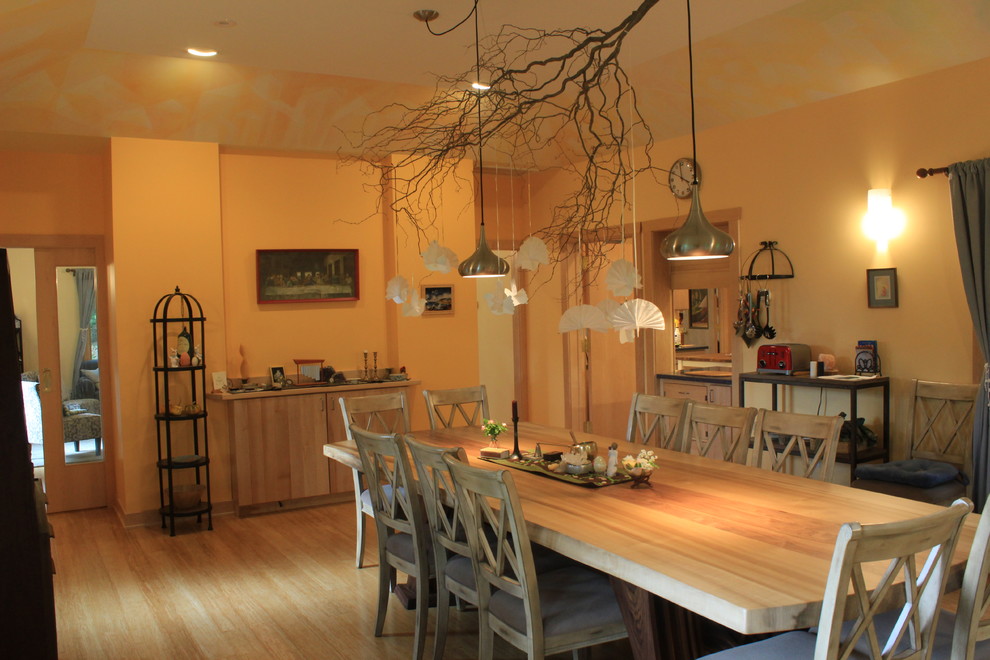 На фото: большая отдельная столовая в стиле неоклассика (современная классика) с полом из бамбука и желтыми стенами без камина с