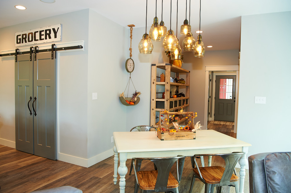 Inspiration pour une grande salle à manger ouverte sur la cuisine rustique avec un mur gris, un sol en vinyl et un sol marron.