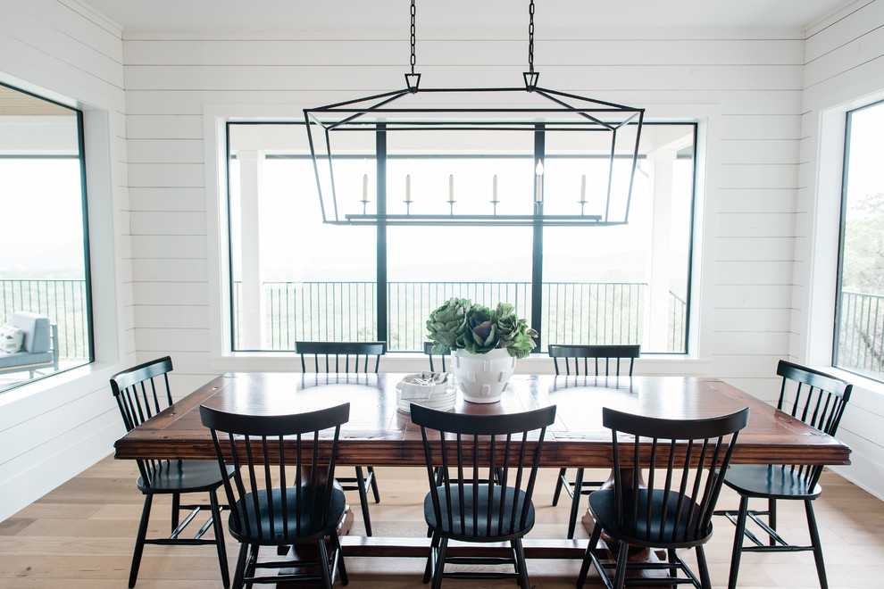 Inspiration pour une salle à manger ouverte sur le salon traditionnelle de taille moyenne avec un mur blanc, parquet clair et un sol marron.