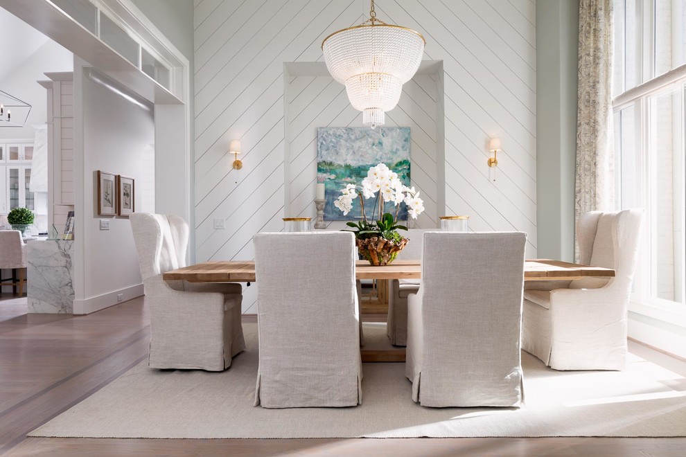 Aménagement d'une salle à manger ouverte sur le salon contemporaine de taille moyenne avec un mur blanc, parquet clair et un sol beige.