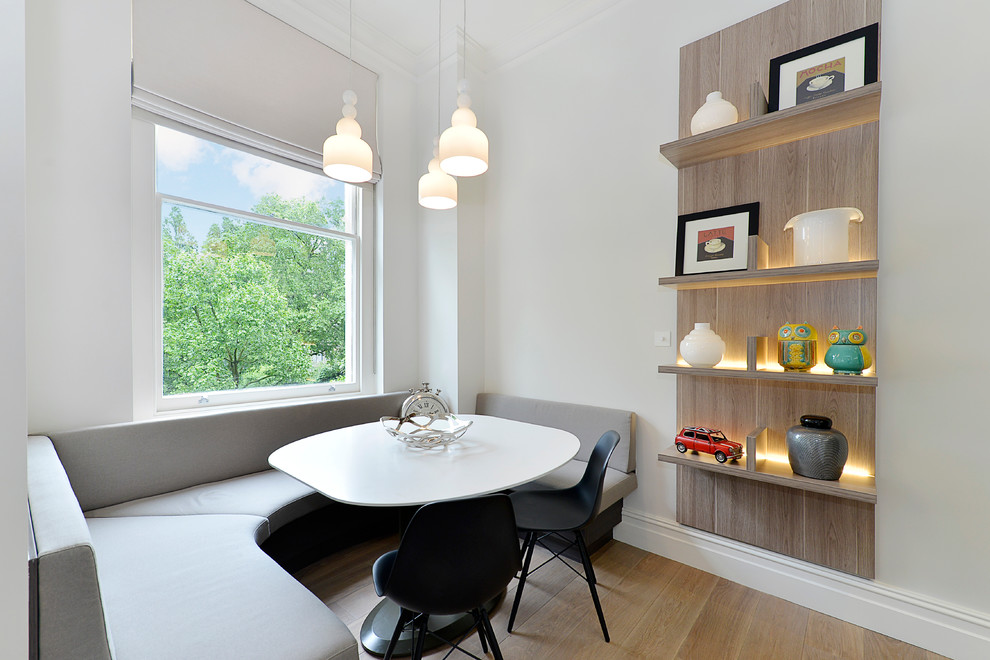 This is an example of a medium sized scandi kitchen/dining room in London with white walls, light hardwood flooring and no fireplace.