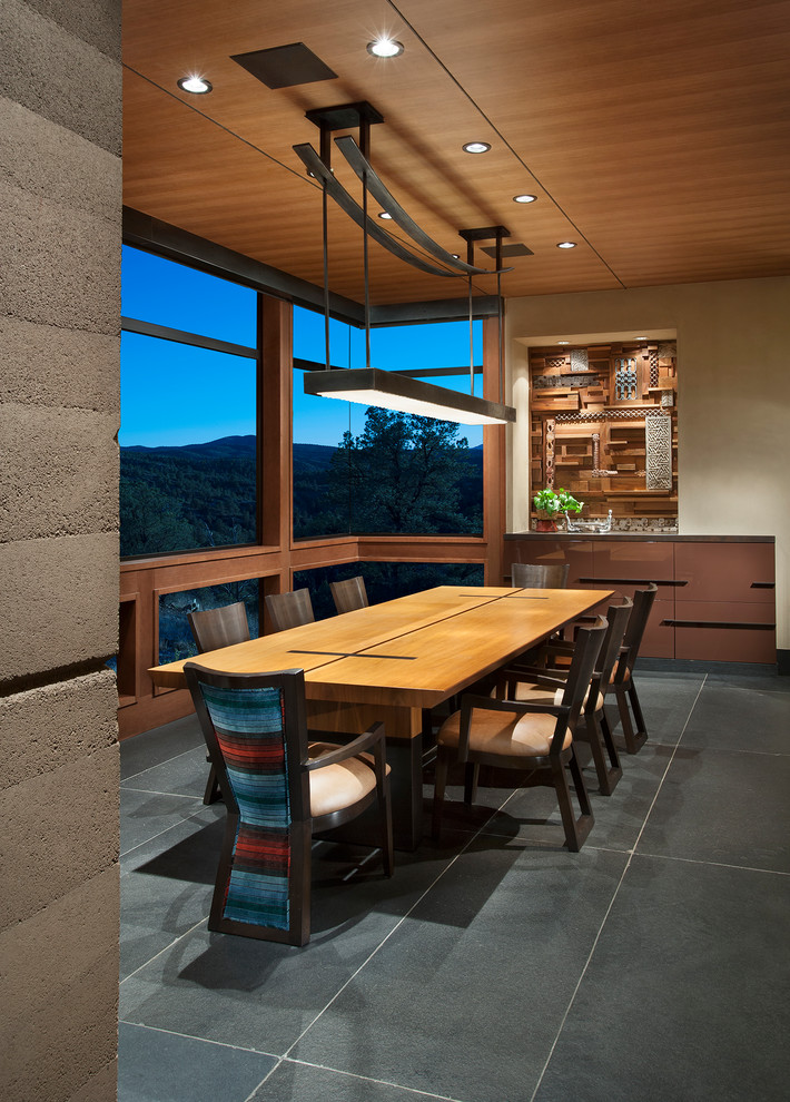 Immagine di una grande sala da pranzo aperta verso la cucina american style con pareti beige, pavimento in ardesia e pavimento grigio