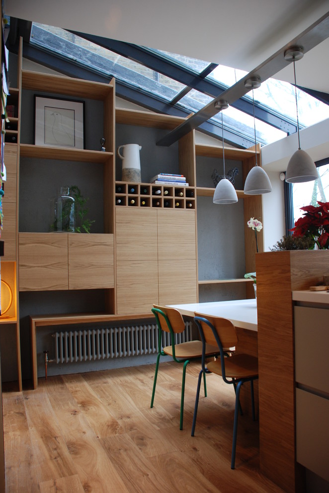 Idee per una sala da pranzo aperta verso il soggiorno minimal con pareti grigie e pavimento in legno massello medio