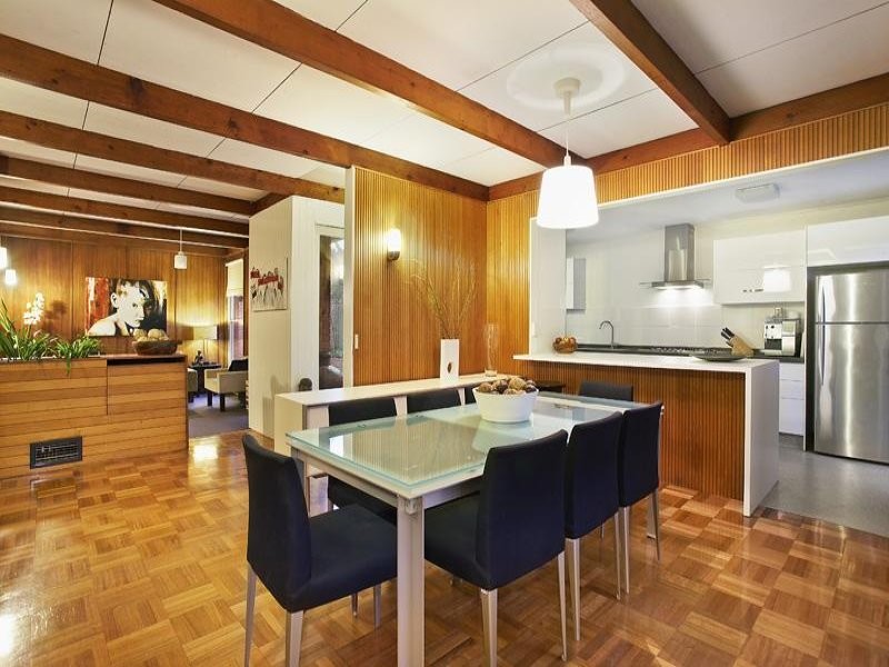 Foto di una sala da pranzo aperta verso la cucina minimalista con pavimento in legno massello medio
