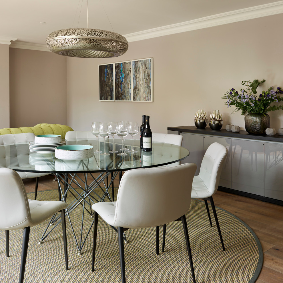 Photo of a contemporary dining room in London with grey walls and medium hardwood flooring.