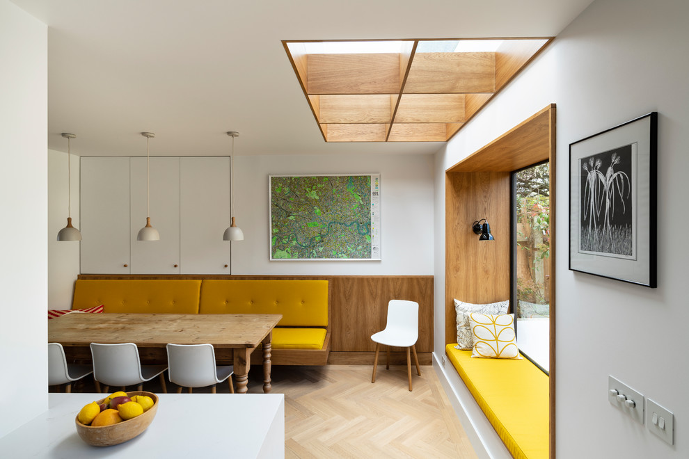 Cette photo montre une salle à manger tendance avec un mur blanc, parquet clair et un sol beige.