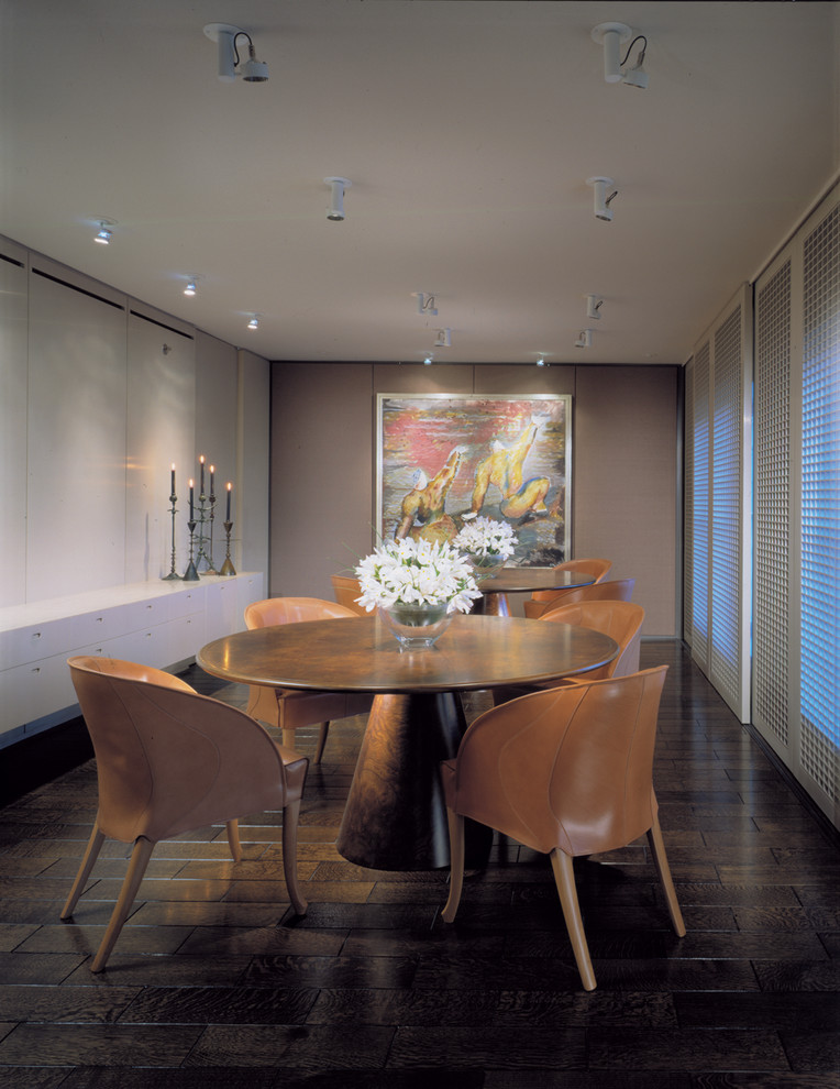 Idée de décoration pour une salle à manger design avec un mur beige et parquet foncé.
