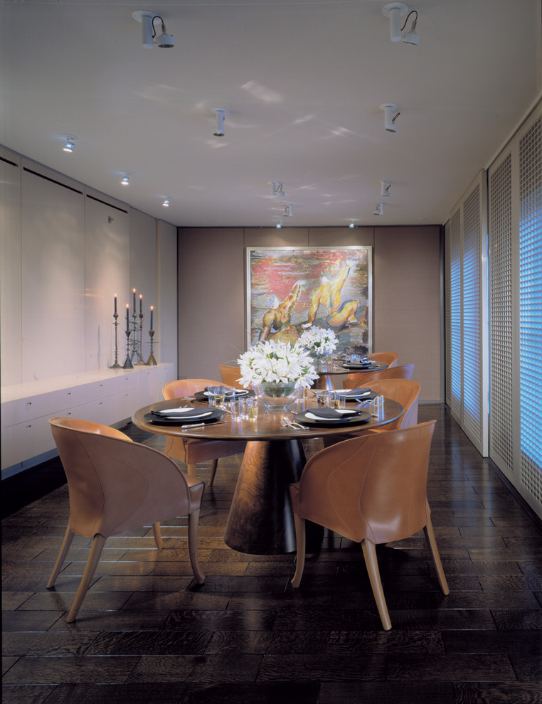 Idée de décoration pour une salle à manger design avec un mur beige et parquet foncé.