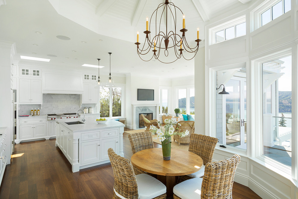 Inspiration pour une salle à manger ouverte sur le salon marine avec un mur blanc et un sol en bois brun.