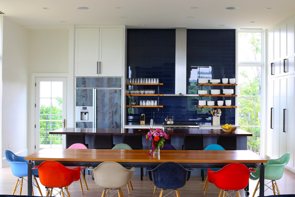 Inspiration pour une salle à manger ouverte sur la cuisine design avec parquet clair et aucune cheminée.